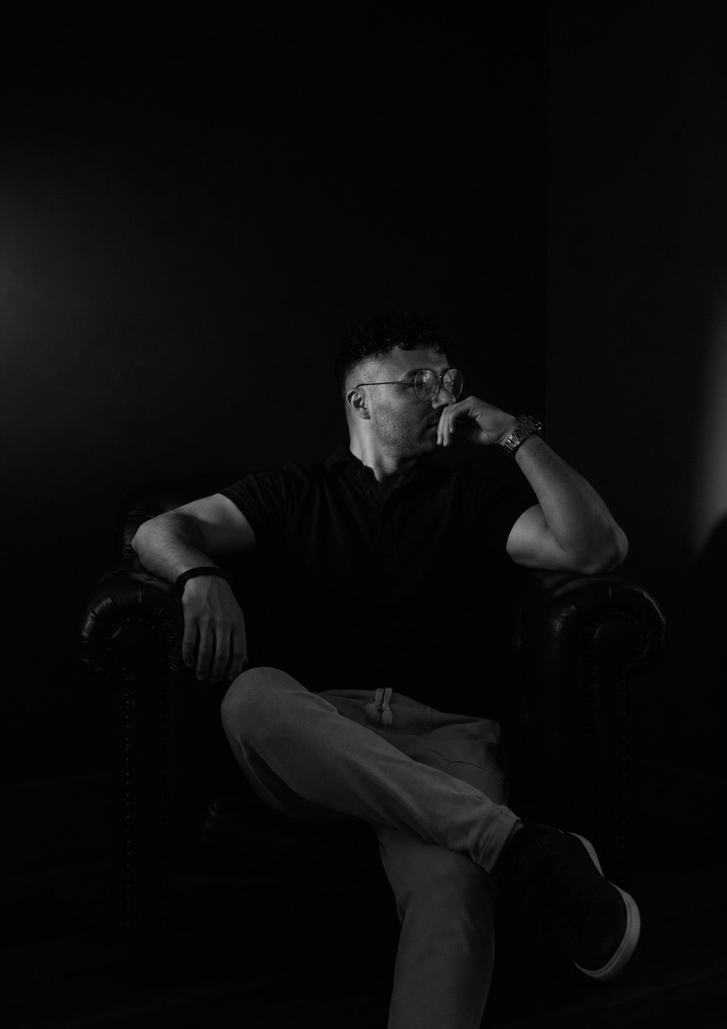 Juan Cubillos — Estratega de Marca, retrato editorial sentado en sillón Chesterfield, blanco y negro